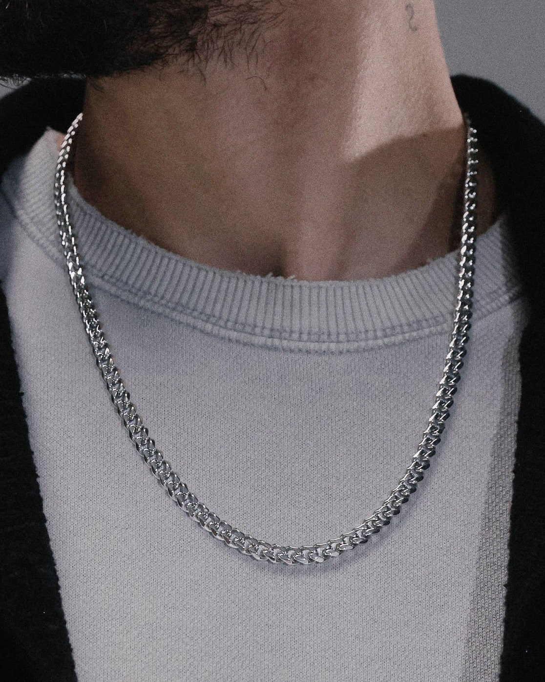 cadena Cubana plateada sobre camiseta, detalle del cuello